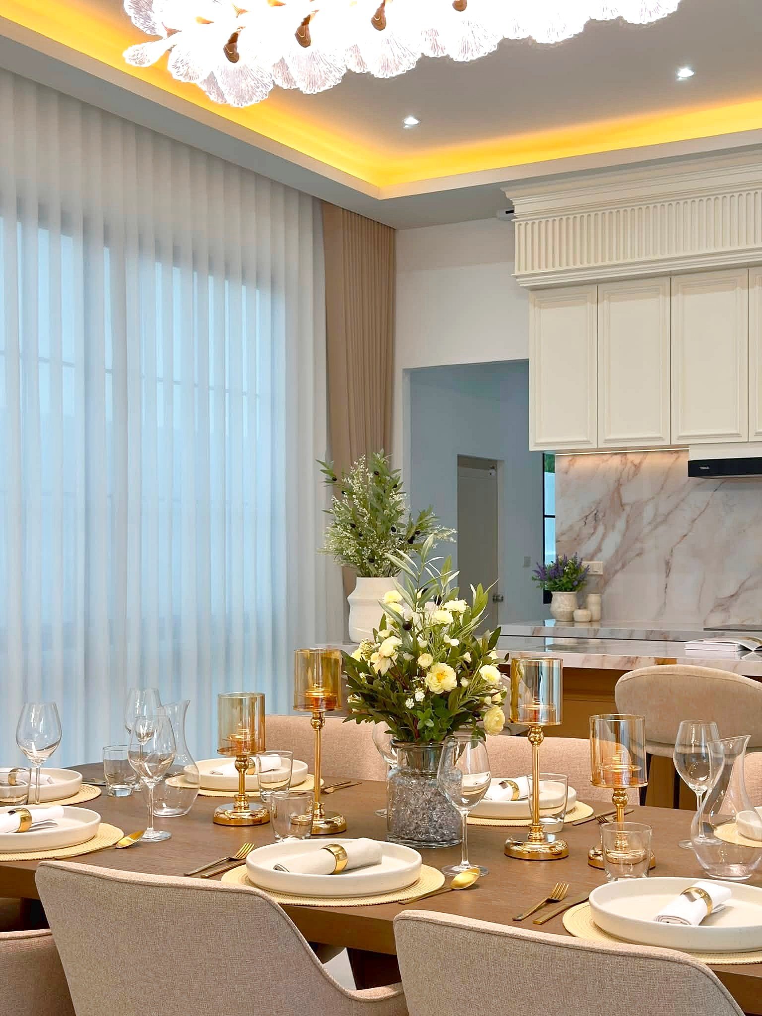 Poolvilla_Soi_Siam_Pattaya_Dlh584_12 Elegant dining table set with white dishes, gold cutlery and candleholders, and a floral centerpiece.