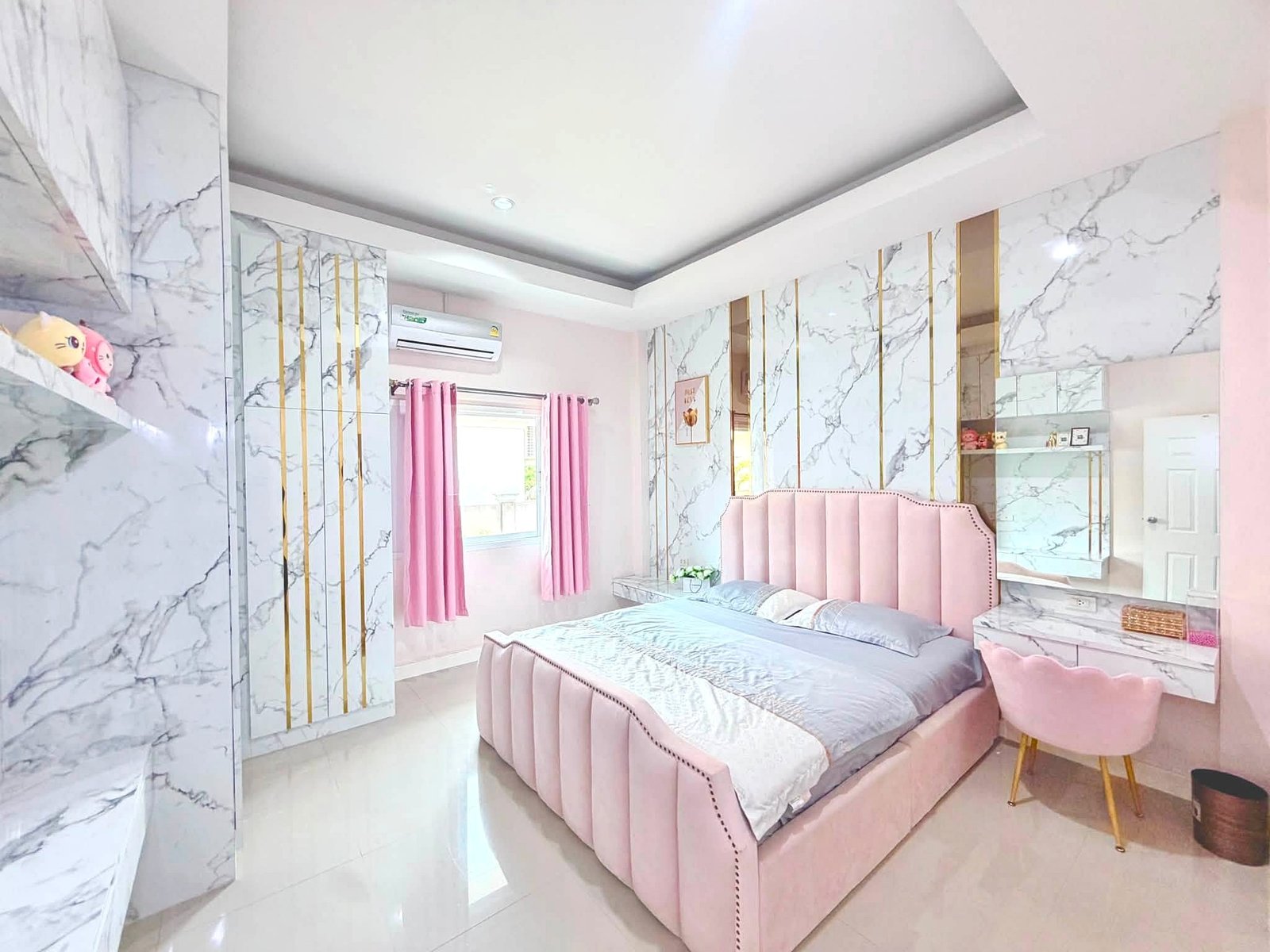 Raviporn_Romsai_Village_Dlh580_5 Pastel pink bedroom with marble-pattern walls, twin beds with pink headboards and matching pink curtains.