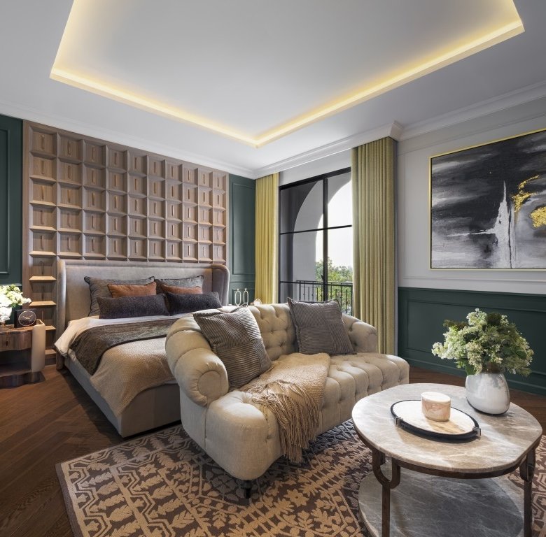 Elegant bedroom with a tufted headboard dark green wall panels and a beige tufted sofa by a round marble coffee table