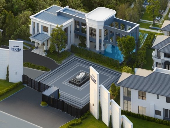 A modern gated estate with white buildings, a central tiled plaza featuring a fountain, and a gate labeled REKHA.
