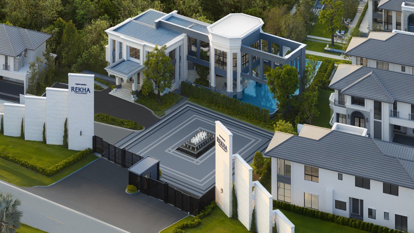 Rekha Pattaya-Motorway 3 Aerial view of a luxury gated residential complex with modern white buildings, a central tiled plaza and fountain, and a rectangular pool area nearby.