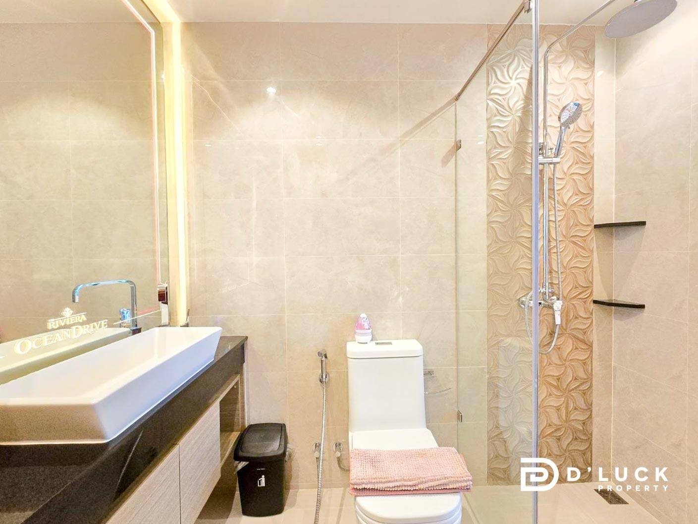 Riviera-Ocean-Drive-Studio-Rent-2609 8 Contemporary bathroom with a rectangular white sink on a dark countertop, large mirror, and a toilet with a pink towel folded on top.