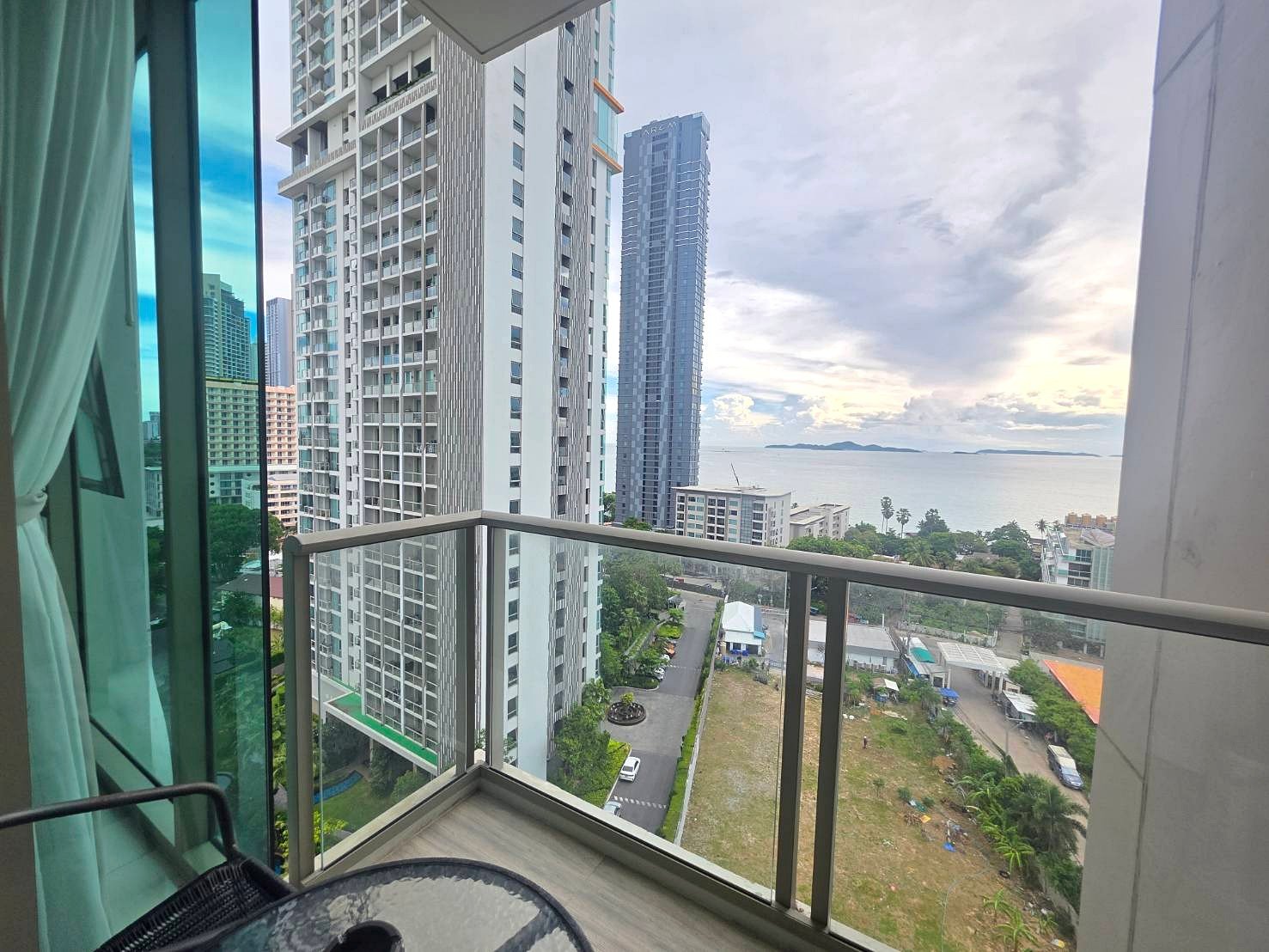 Riviera_Wongamat_B1209_8 Balcony view of tall white apartment buildings with the sea and distant islands beyond.