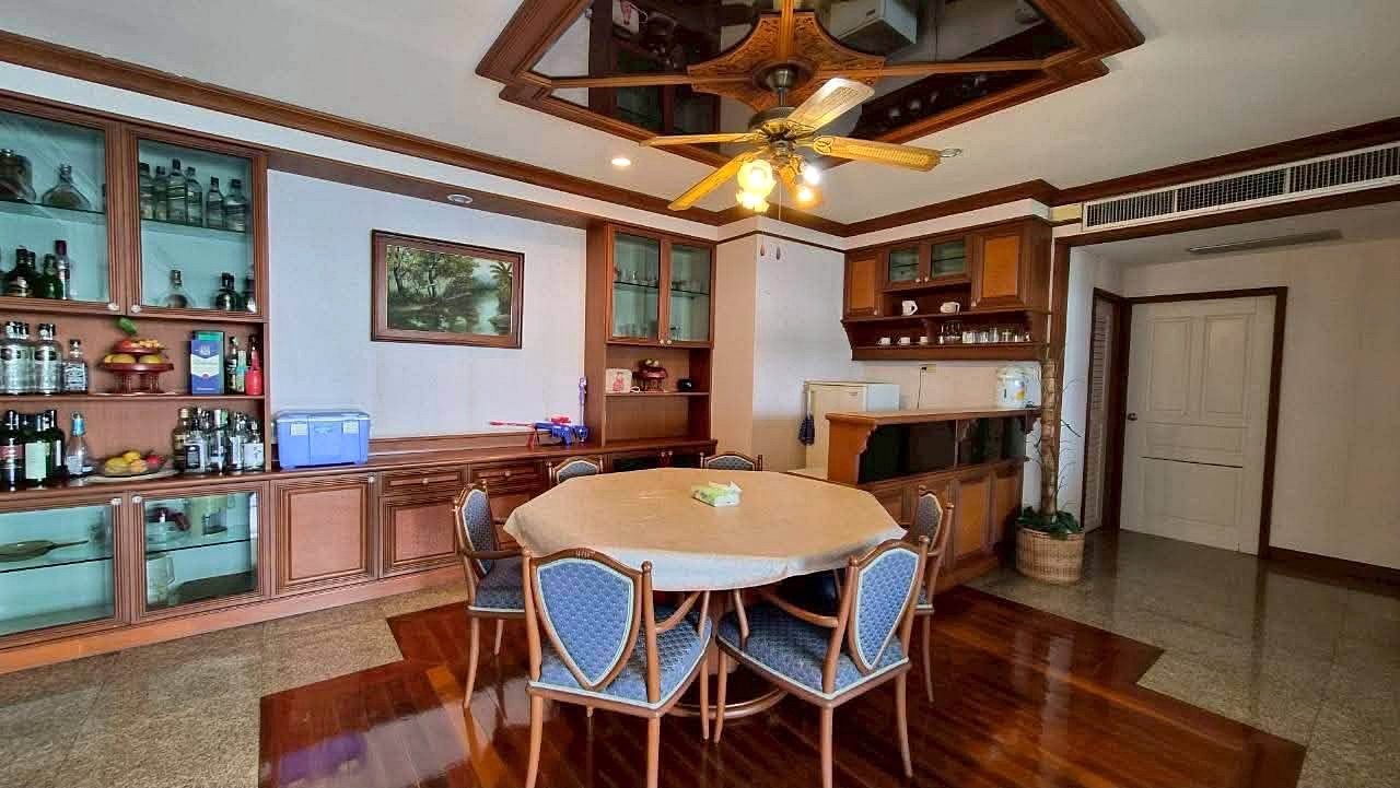 Royal_Cliff_Garden_Pattaya_Dlc639_4 Round dining table with a beige tablecloth and blue-upholstered chairs in a wood-paneled dining room with a ceiling fan above
