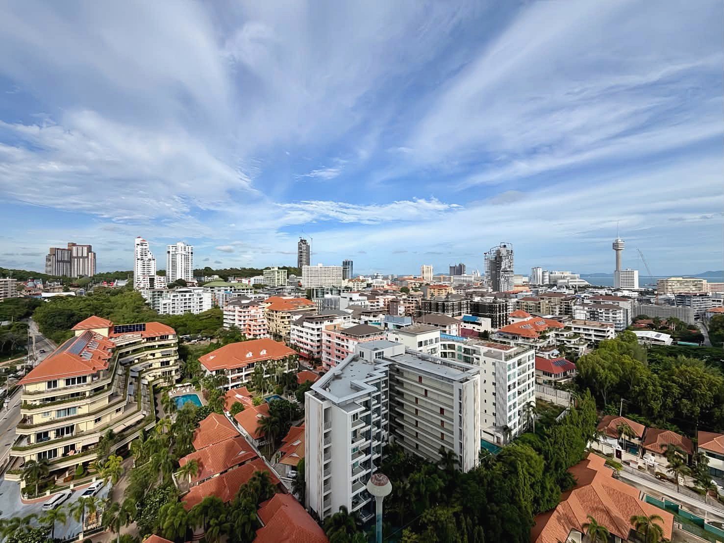 The_Peak_Tower_Rent_Rdl340_22 City skyline with many mid-rise buildings and red-tiled roofs under a blue, cloudy sky. For a coastal city view.