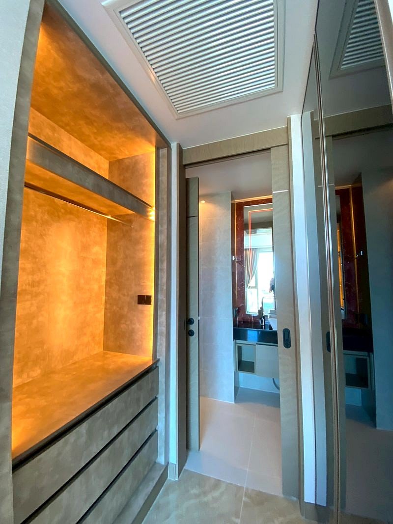 The_Riviera_Ocean_Drive_3714_9 Walk-in closet with warm backlit shelves and gray drawers beneath the lighting glow.