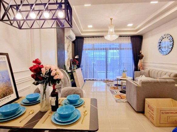 Dining table set with blue bowls and gold cutlery in a bright living room