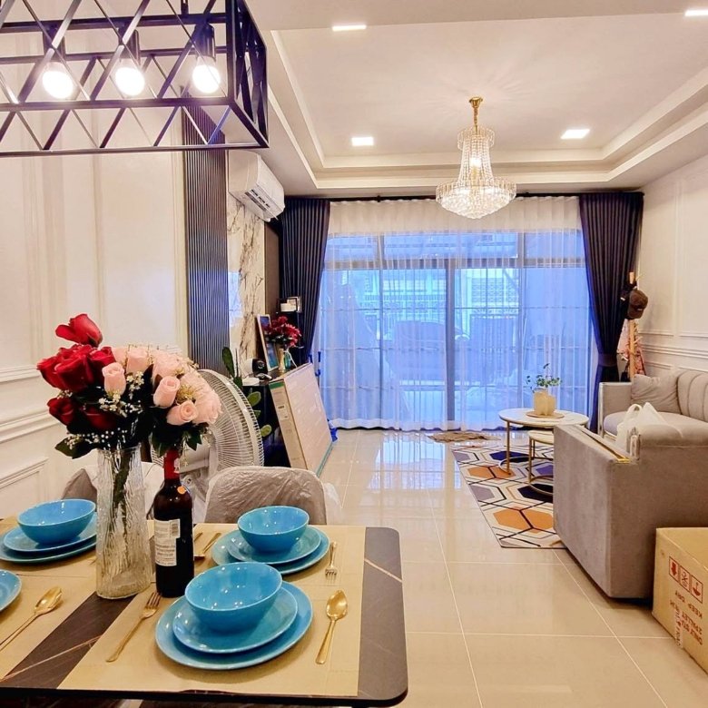 Dining table set with blue bowls and gold cutlery in a bright living room