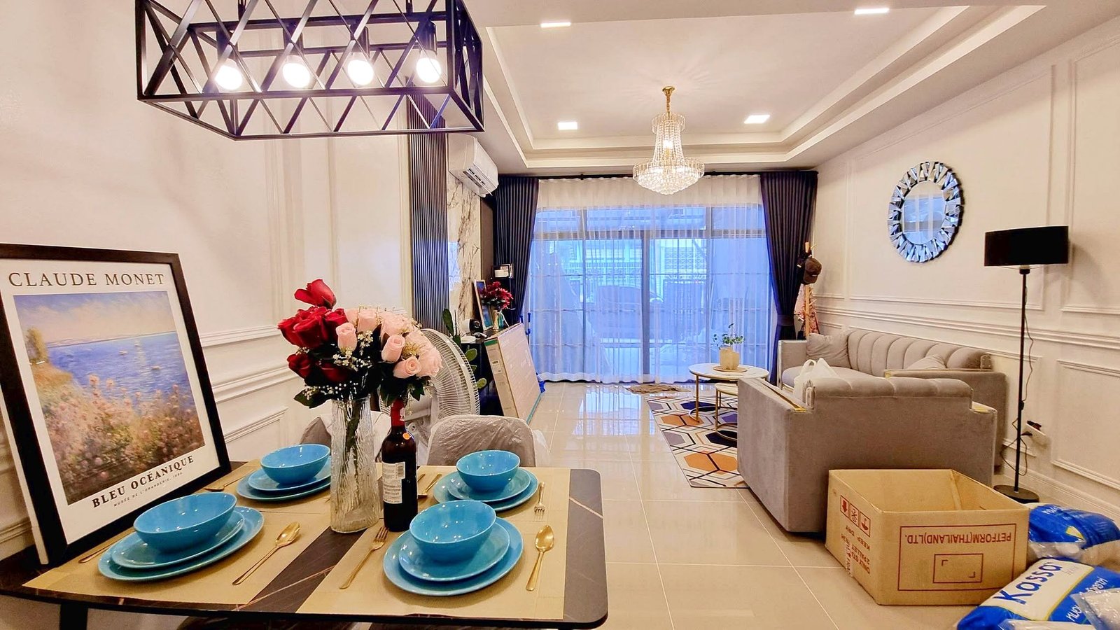 Townhome_South_Pattaya_Dlh581 Dining table set with blue bowls and gold cutlery in a bright living room.
